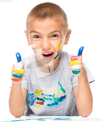 Image of Portrait of a cute boy playing with paints