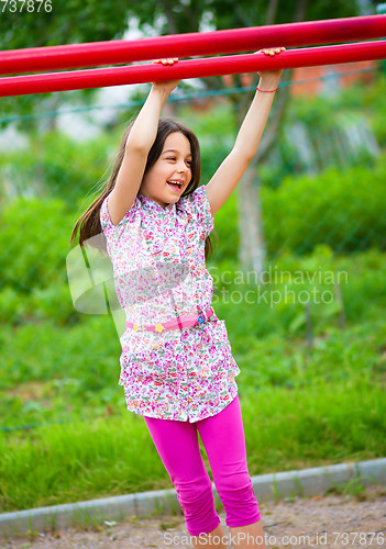 Image of Cute little girl is playing in playground