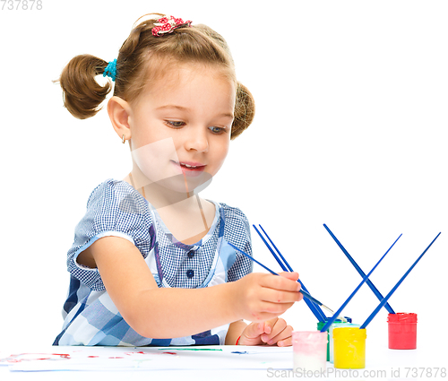 Image of Little girl is painting with gouache