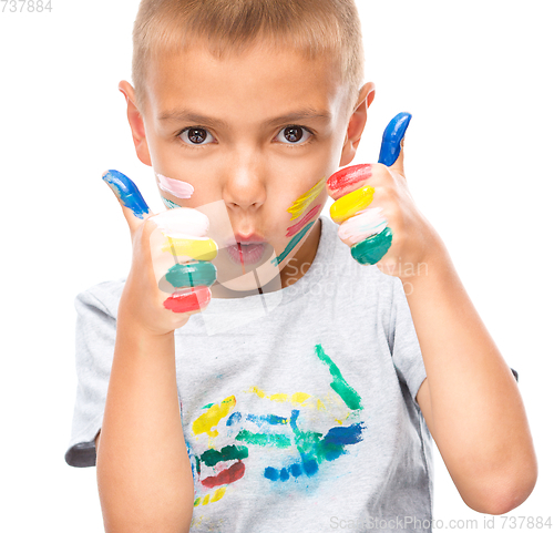 Image of Portrait of a cute boy playing with paints