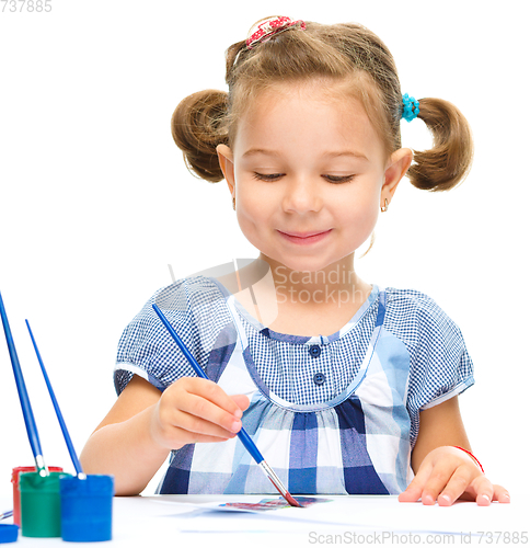 Image of Little girl is painting with gouache