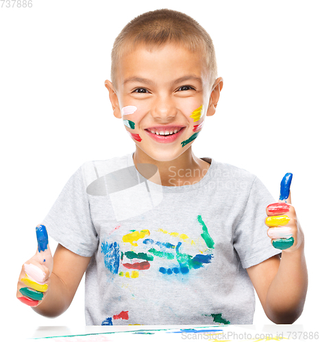 Image of Portrait of a cute boy playing with paints