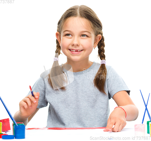 Image of Little girl is painting with gouache