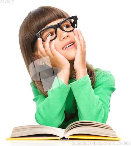 Image of Young girl is daydreaming while reading book