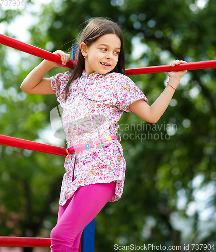 Image of Cute little girl is playing in playground