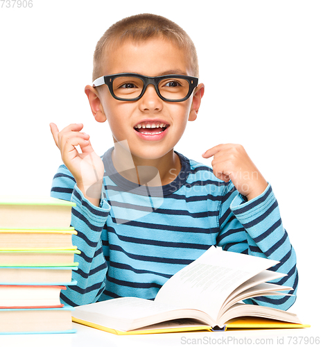 Image of Young boy is daydreaming while reading book