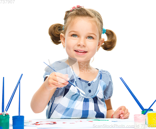 Image of Little girl is painting with gouache