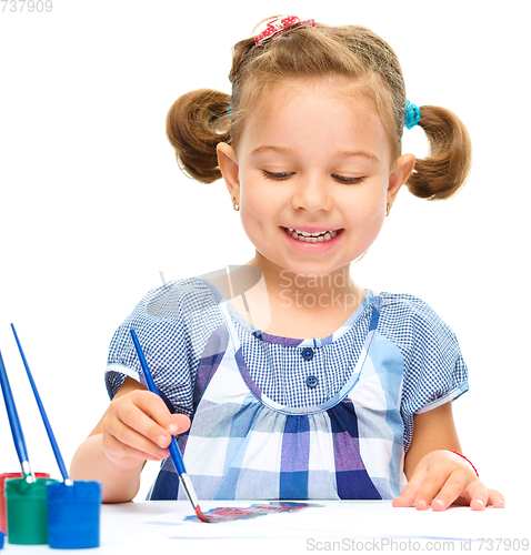 Image of Little girl is painting with gouache