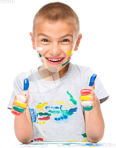 Image of Portrait of a cute boy playing with paints