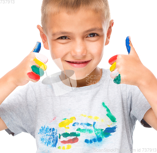 Image of Portrait of a cute boy playing with paints
