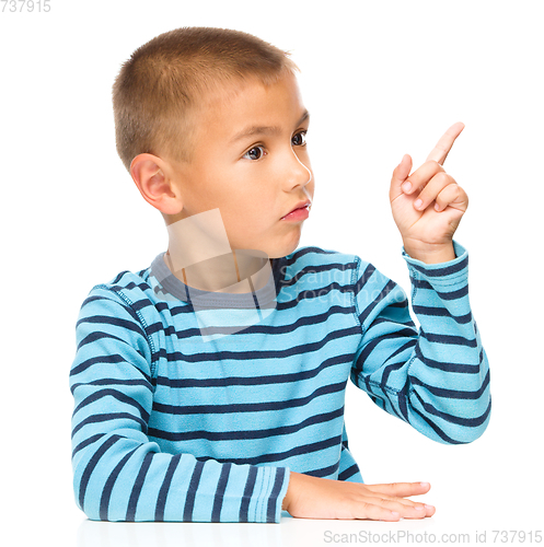 Image of Boy is pointing to the right with index finger