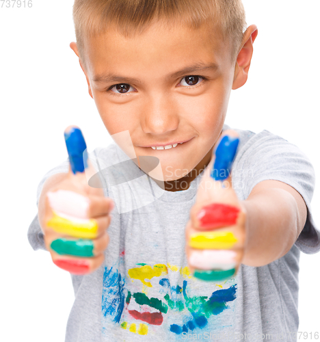 Image of Portrait of a cute boy playing with paints