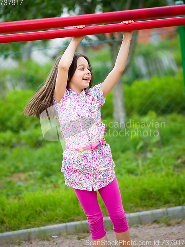 Image of Cute little girl is playing in playground