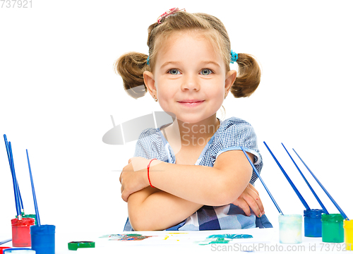 Image of Little girl is painting with gouache