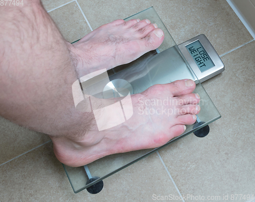 Image of Man\'s feet on weight scale - Lose weight