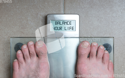 Image of Man\'s feet on weight scale - Balance your life