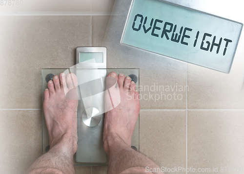 Image of Man\'s feet on weight scale - Overweight