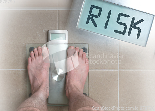 Image of Man\'s feet on weight scale - Risk