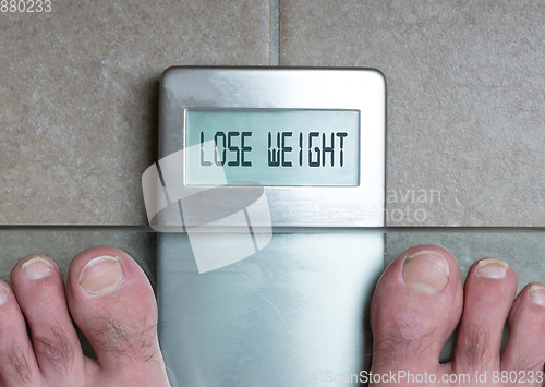 Image of Man\'s feet on weight scale - Lose weight