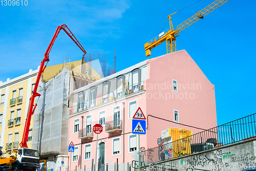 Image of Construction cranes by appartment building