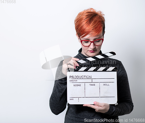 Image of redhead woman holding movie  clapper on white background