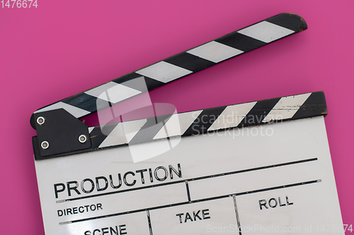 Image of movie clapper on pink background