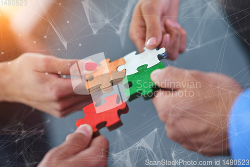 Image of Group of business people assembling jigsaw puzzle