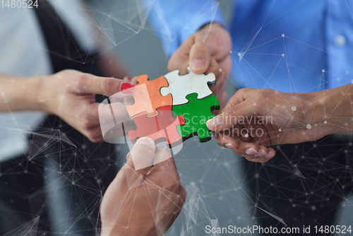 Image of Group of business people assembling jigsaw puzzle