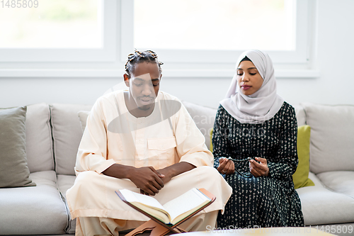 Image of african couple at home reading quran