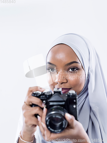 Image of african modern muslim woman using retro camera