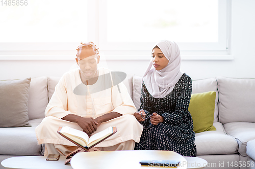Image of african couple at home reading quran
