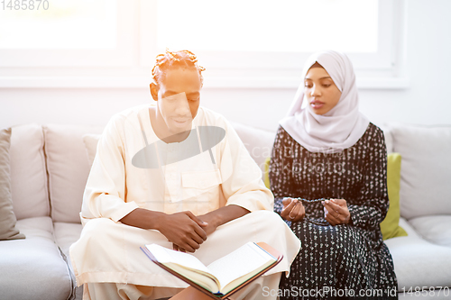 Image of african couple at home reading quran