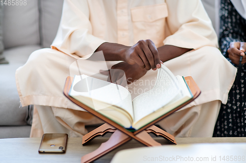 Image of african couple at home reading quran