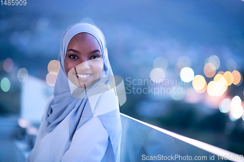 Image of African  modern Muslim woman in night at balcony