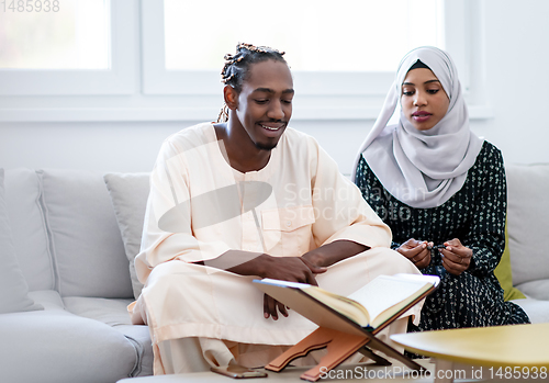 Image of african couple at home reading quran