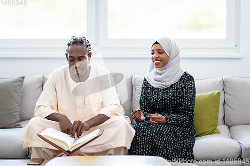 Image of african couple at home reading quran