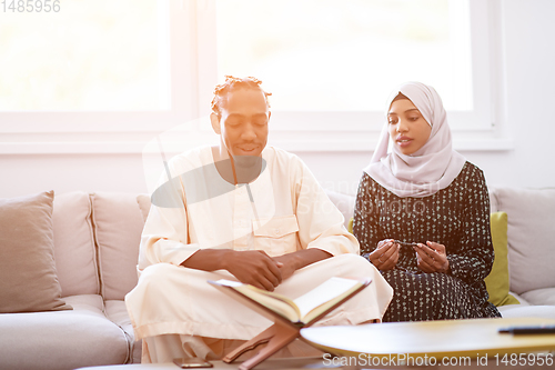 Image of african couple at home reading quran