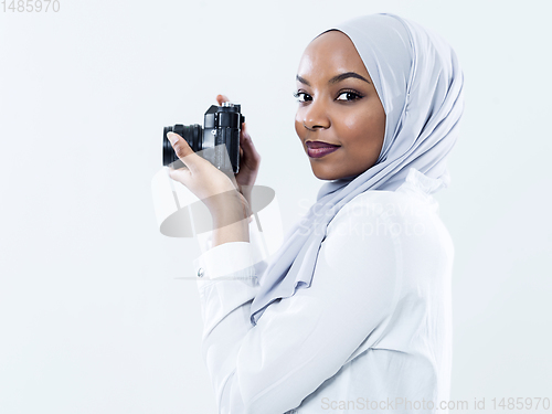 Image of african modern muslim woman using retro camera