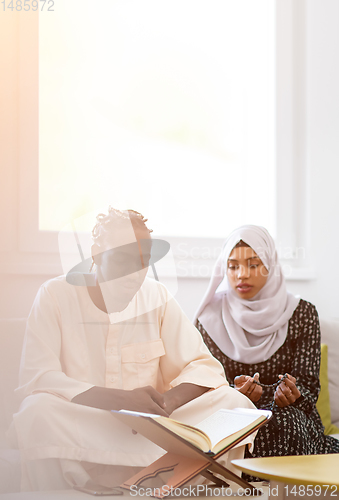 Image of african couple at home reading quran