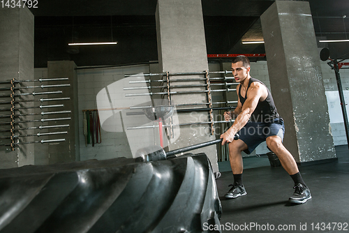 Image of A muscular male athlete doing workout at the gym