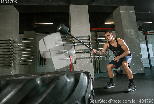 Image of A muscular male athlete doing workout at the gym