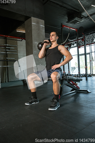 Image of A muscular male athlete doing workout at the gym