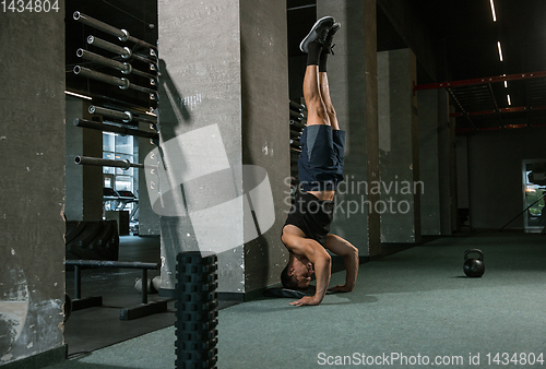 Image of A muscular male athlete doing workout at the gym