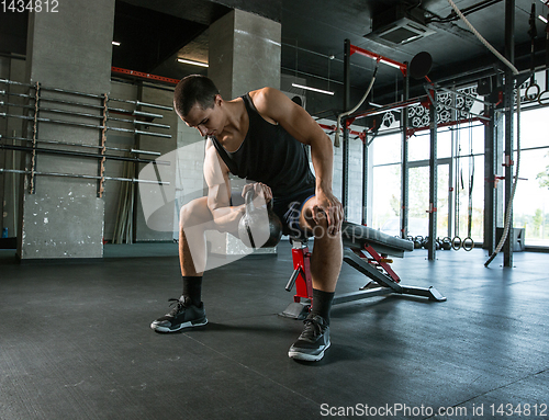 Image of A muscular male athlete doing workout at the gym