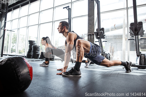 Image of A muscular athletes doing workout at the gym