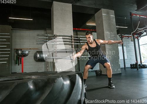 Image of A muscular male athlete doing workout at the gym