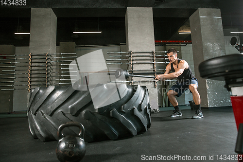 Image of A muscular male athlete doing workout at the gym