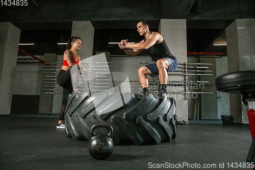 Image of A muscular athletes doing workout at the gym