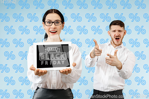 Image of Portrait of couple showing screen of mobile phone, black friday