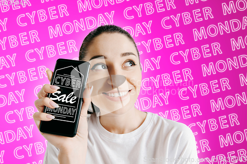 Image of Portrait of woman showing screen of mobile phone, black friday